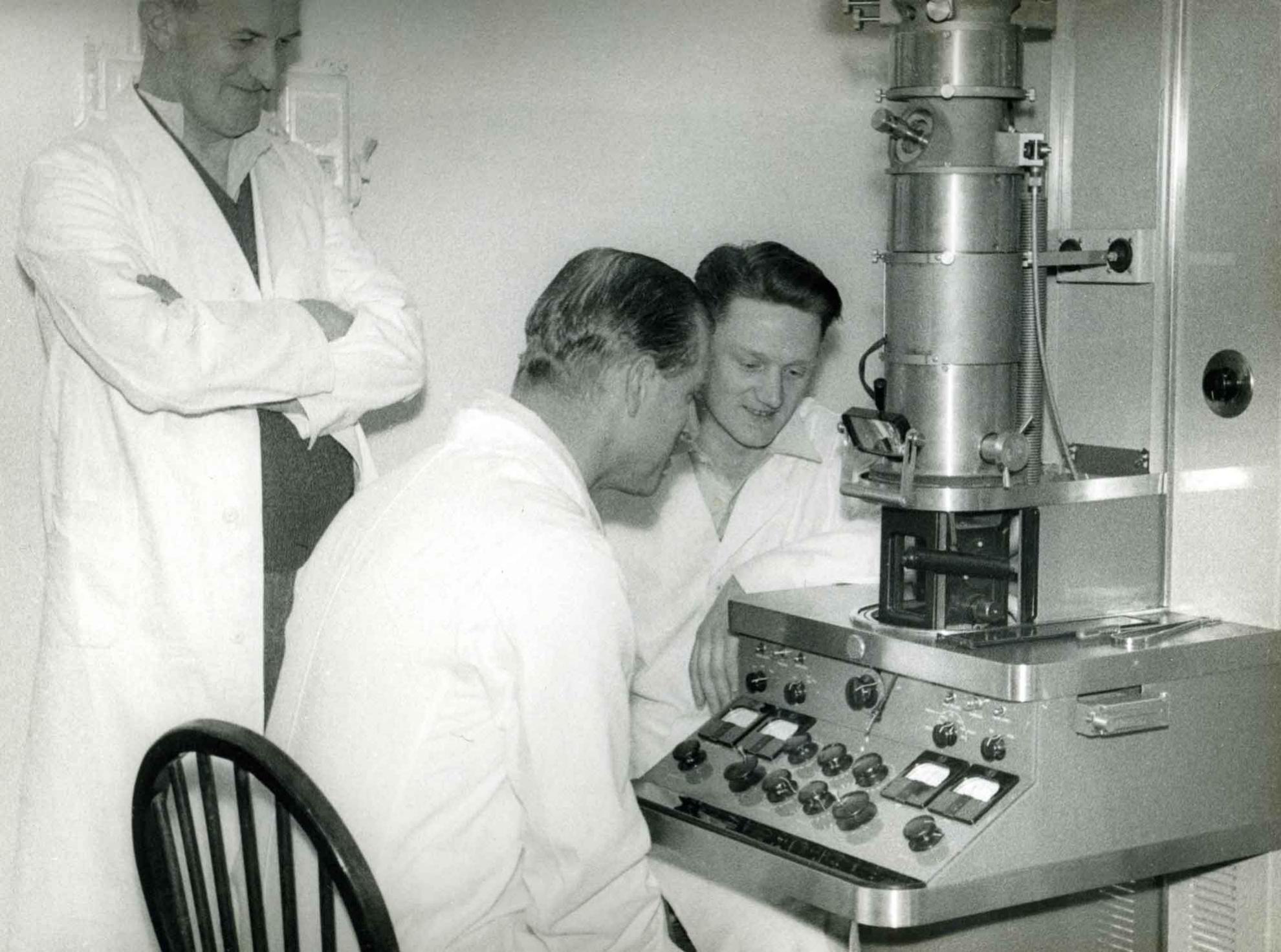 Prince Philip sits at early transmission electron microscope at Pirbright in 1956