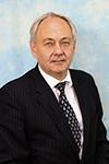 Professor John Stephenson in a dark suit and tie in front of a pale blue backdrop