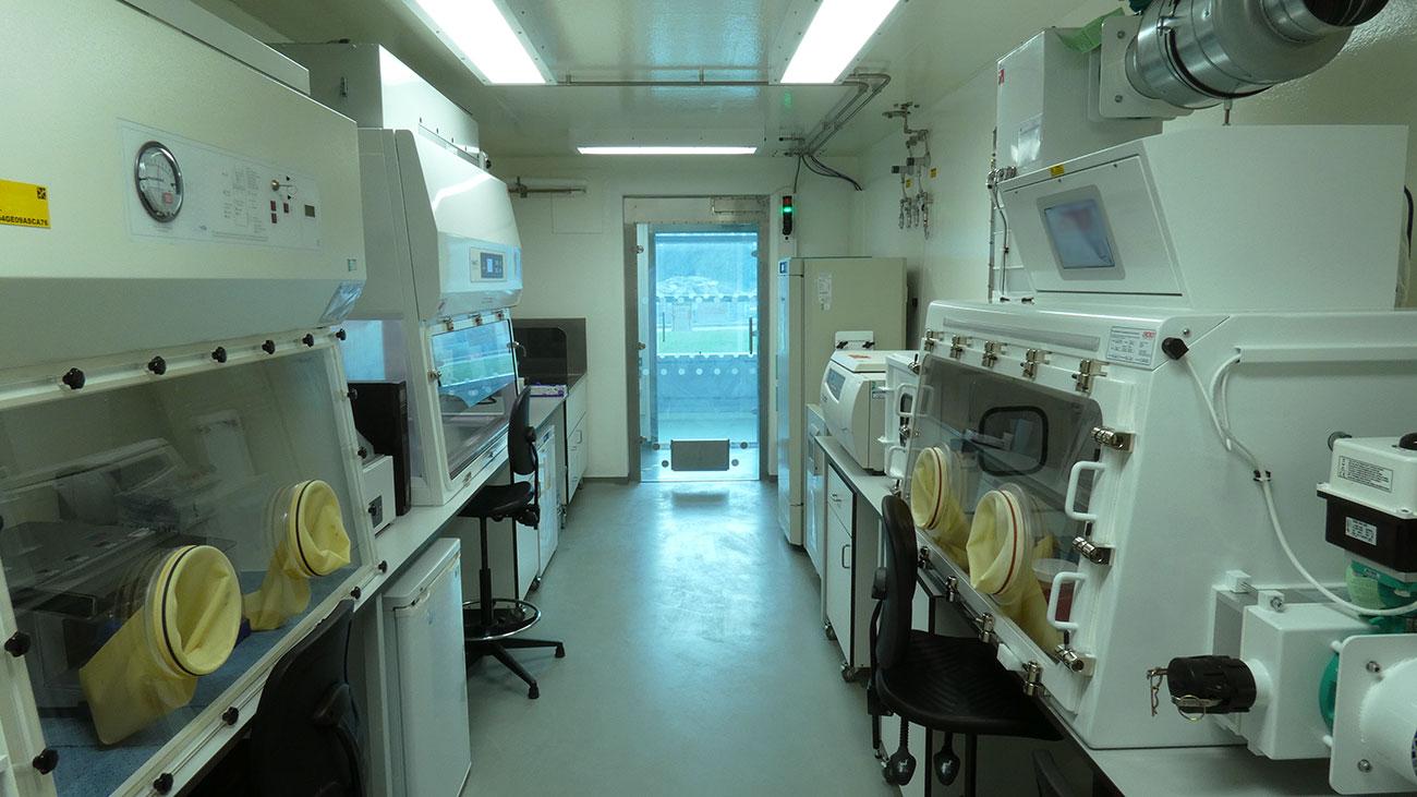 An empty CL3 laboratory at The Pirbright Institute. There are three Biological safety cabinets, two of which have yellow gloves that go into the cabinet 